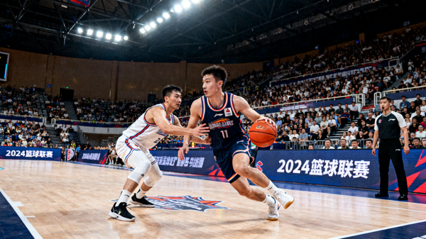 篮球比赛现场球员在球馆内进行攻防对抗的赛事画面